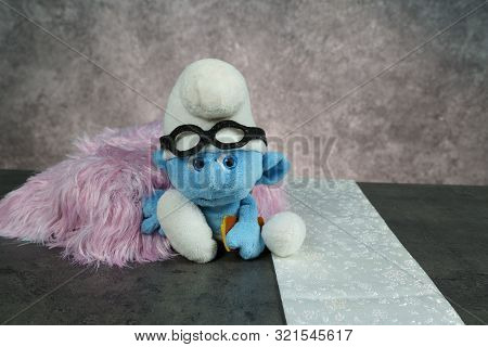 Tallinn, Estonia 10 09 2019 : Blue Smurf With Glasses On Concrete Table