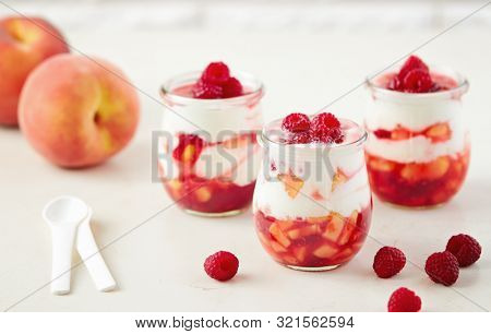 Homemade peach and raspberry dessert with yogurt cream