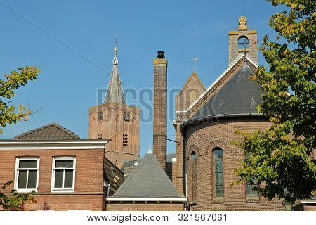 Historic Houses Located Inside The Fortified Town Of Naarden, Netherlands, With The Clock Tower Of T