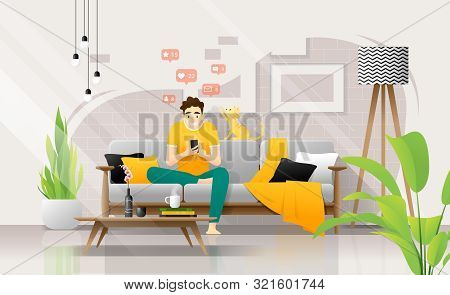 Happy Young Man Using Smartphone While Sitting On Sofa In Living Room, Relaxing At Home With His Cat