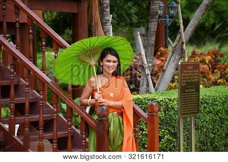 Kanchanaburi, Thailand, 09.09.2019: Beautiful Thai Girl In Traditional Thai, Siamese Dress With Gree
