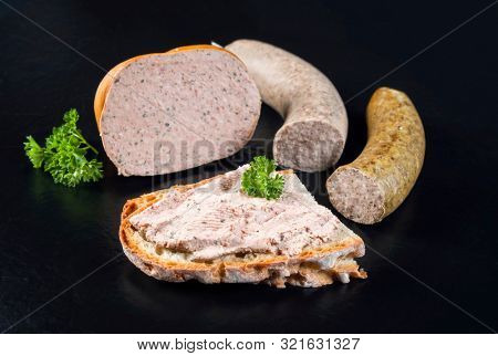 Traditional German meat paste with farmhouse bread offered as closeup on a black board with copy space 