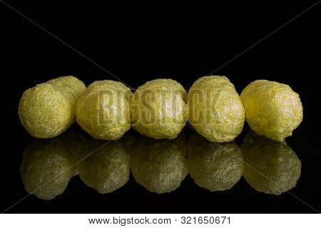Group Of Five Whole Salted Yellow Corn Puff Isolated On Black Glass