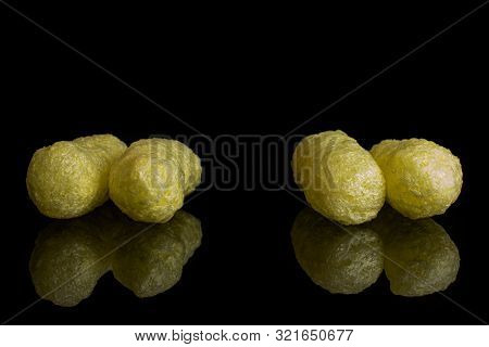 Group Of Four Whole Salted Yellow Corn Puff Isolated On Black Glass