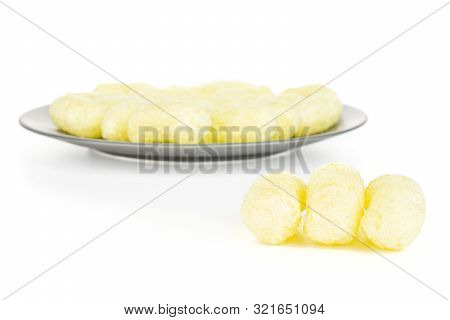 Lot Of Whole Salted Yellow Corn Puff On Gray Ceramic Plate Isolated On White Background