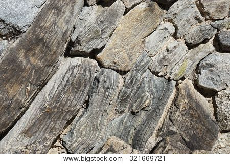 Dry Stone Fence Made Of Stacked Rocks With Natural Striations