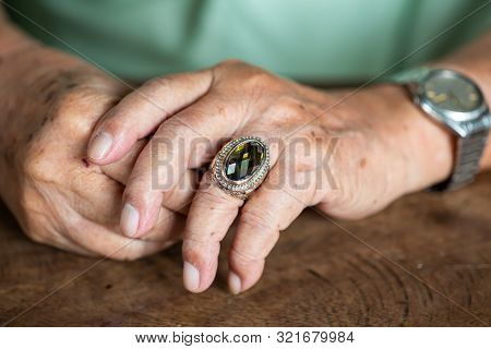 Senior Man Is Wearing Jewellery Ring In Left Ring Finger And Silver Watch On Wooden Background, Sebo