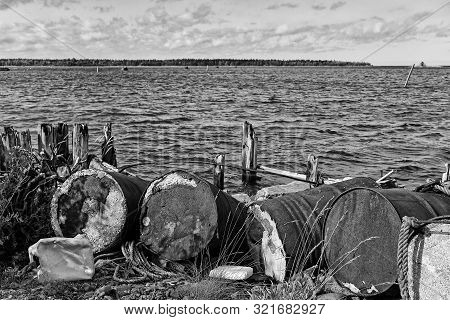 Old Barrels Have Been Left To Rot By The Remains Of An Old Wooden Pier At The Fishing Harbour Of Kal