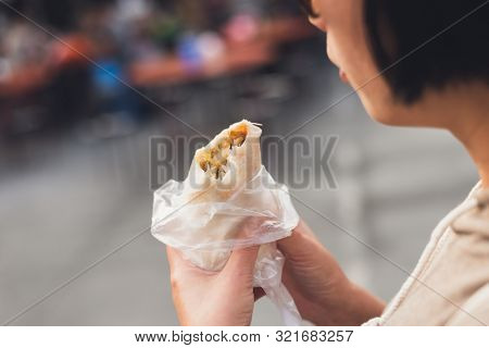 woman eat traditional Taiwanese snack of spring roll
