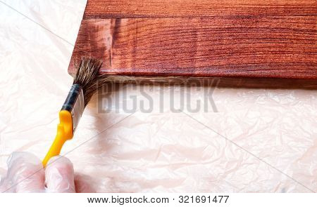Close Up Hand Use Brush Paint Clear Lacquer On The Wood Surface. Hands Are Protected By Gloves. Fini