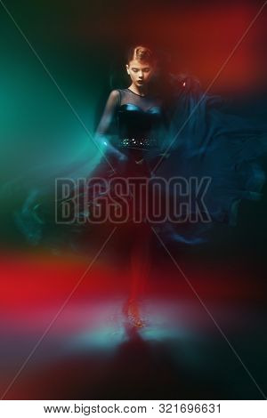 Beautiful girl performs Latino dance with expression. Professional dancer in motion. Beauty, fashion.