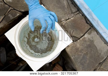 Female Hand Puts White Tablets Into Pool Skimmer. Cleaning, Disinfection Of Water In The Swimming Po