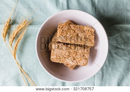 Cereal Bars In Breakfast Bowl With Wheat Ears Next To It - Top View Photo