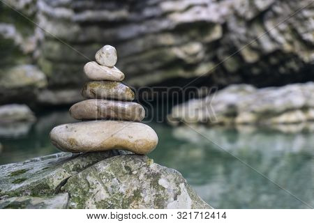 Harmony, Balance And Simplicity Concept. A Stone Pyramid On The Background Of River Water. Simple Po
