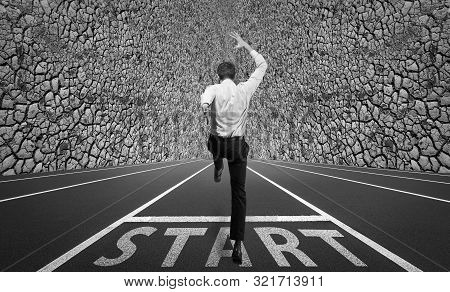 Businessman Jumping On A Starting Grid With The Wall On The Background. Caucasian Man, Empoyer In Su