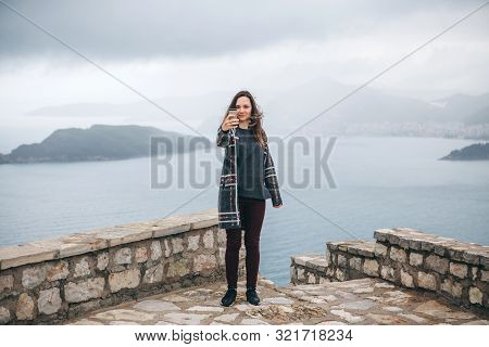 A Tourist Girl Or A Blogger Takes Pictures Or Records Videos Of A Sea View. Or She Takes A Selfie.