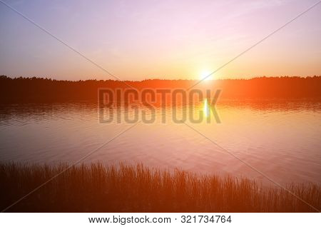 Sunset Over The Lake. The Sky Is In Red Rays.
