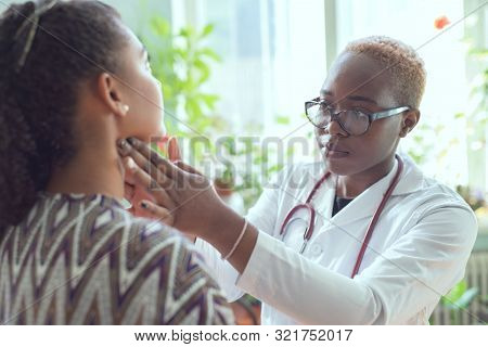 African Female Doctor Watching Patient With Sore Throat