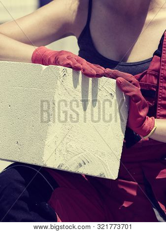 Unrecognizable Woman Working On Construction Site, Building House, Installing Gray Airbricks. Indust