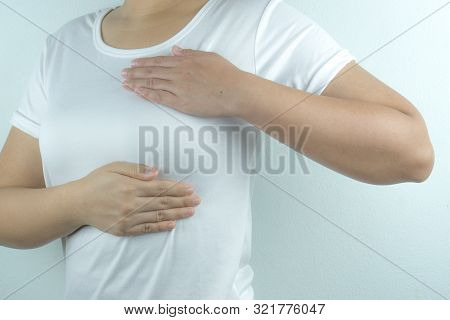 Woman Hands Doing Breast Self-exam For Checking Lumps And Signs Of Breast Cancer On Grey Background.