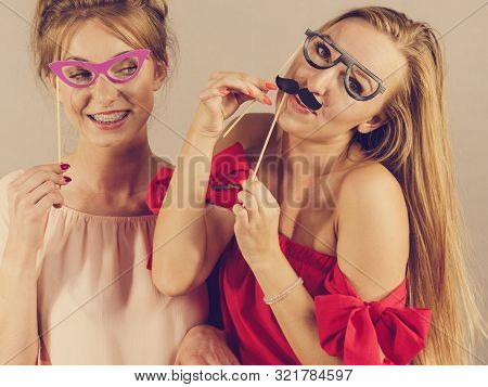Happy Two Women Holding Paper Decoration Photo Booth Mask Glasses And Moustache On Stick, Having Fun
