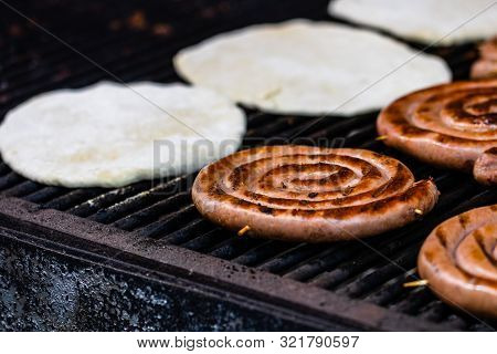 Meat Sausages And Pita Bread On The Grill At A Street Food Festival