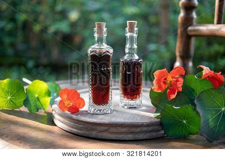 Bottles Of Herbal Tincture With Fresh Bloomingtropaeolum Majus Plant
