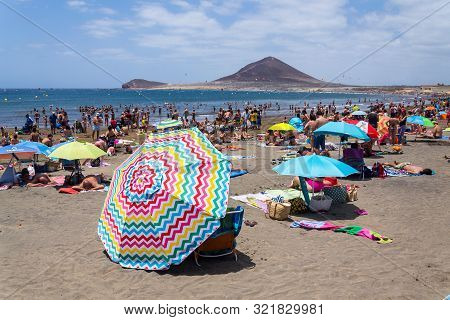 El Medano, Spain - July 7 2019: People Swimming And Sunbathing On Playa El Medano Beach On July 7, 2