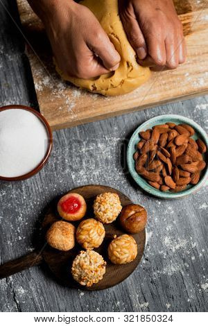 high angle view of a young caucasian man preparing some panellets, sweet food typically eaten in All Saints Day in Catalonia, Spain