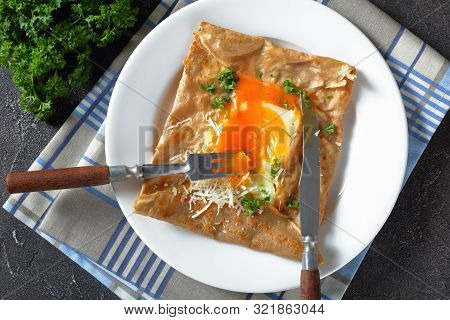 Breton Crepe, Savory Buckwheat Galettes Bretonnes With Spilled Egg, Cheese, Ham On A White Plate On 