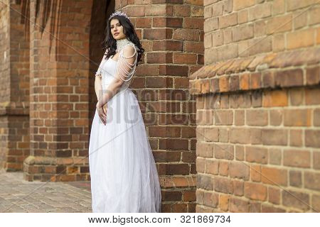 Portrait Of Romantic Sensual Caucasian Bride With Crown And Necklace Posing Against Old Brick Wall O