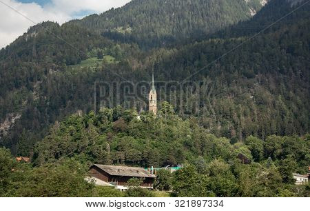 Old Church On A Wooded Mountain At Blue Sky In The Swiss Alps