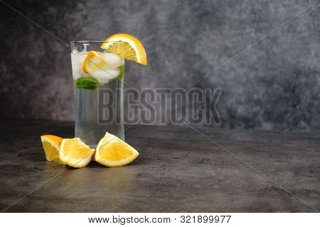 Fresh Water, Oranges And Orange Tree In Pot On Grey Background