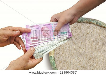 Hand Giving Indian 500 And 2000 Rupee Bank Notes Over Bag, Burlap Full Of Rice In Burlap Sack.