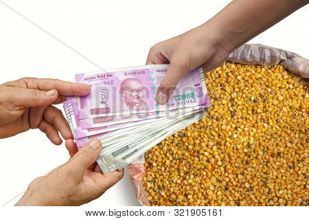 Hand Giving Indian 500 And 2000 Rupee Bank Notes Over Bag Full Of Chickpeas, Yellow Chana Split Peas