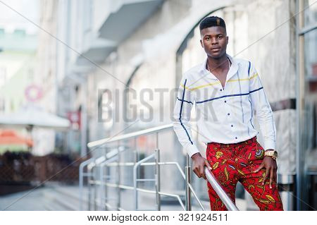 Portrait Of Handsome Stylish African American Model Man In Red Throusers And White Shirt.