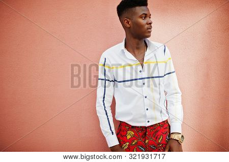 Portrait Of Handsome Stylish African American Model Man In Red Throusers And White Shirt Against Pin