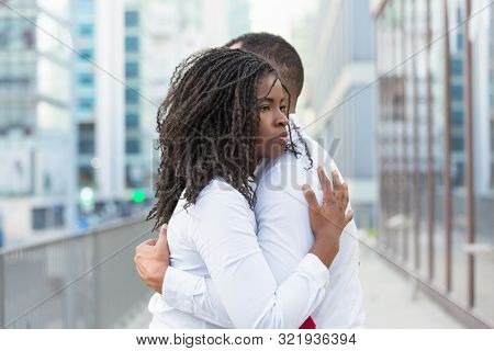 Young Couple Standing In City Street And Embracing Each Other. Diverse Close Friends Wearing Shite S