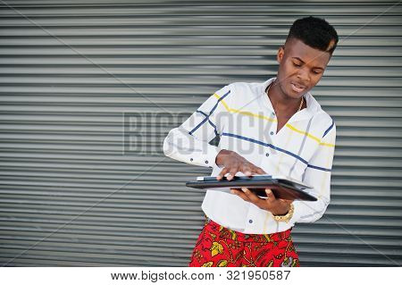 Portrait Of Handsome Stylish African American Model Man In Red Throusers And White Shirt With Laptop