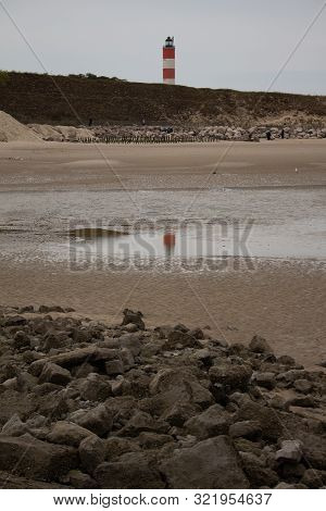 A Lighthouse Reflecting At Low Tide Under The Grisaille