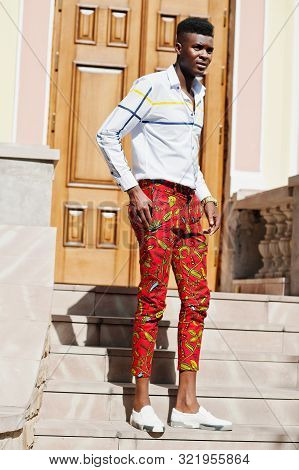 Portrait Of Handsome Stylish African American Model Man In Red Throusers And White Shirt.