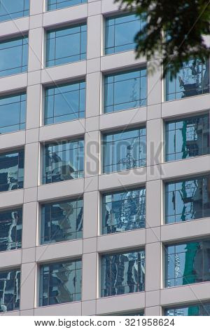 Glass windows and concrete walls in the daytime. Arcitectural fragment of modern building in Bangkok, Thailand.