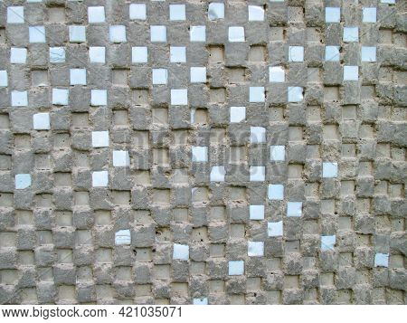 An Old Gray Wall Of A House With Small Squares Of Blue Smalt Arranged In A Checkerboard Pattern. Ove
