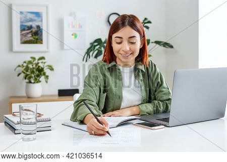 Woman Remotely Working At Home With Laptop Computer. Young Businesswoman Planning Her Time. Concept 