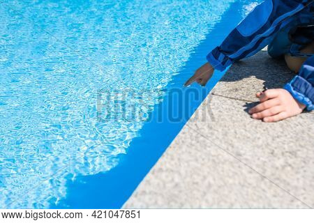 A Child's Hand Touches The Blue Water In The Pool , Swimming Pool And Mramor Deck Ideal For Backgrou