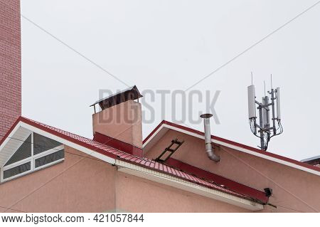 Telecommunication Antenna Next To The Chimney And Residential Building. Cellular And Telephone Commu