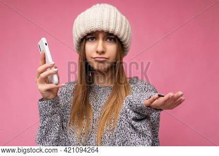 Closeup Portrait Of Beautiful Sad Upset Young Blonde Woman Wearing Casual Grey Sweater And Beige Hat