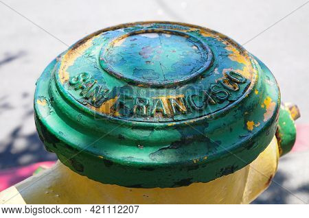 Fire Hydrant A Little Ruined And Painted Green And Yellow With The Name Of The City Of San Franciso 
