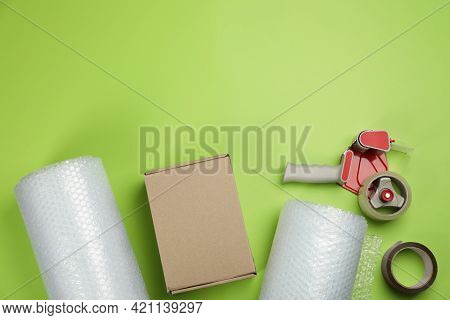 Flat Lay Composition With Bubble Wrap Rolls On Green Background, Space For Text