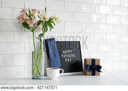Happy Fathers Day Concept. Letterboard, Tie, Gift Box, Coffee Cup, Boquet Of Flowers On Table. Nordi